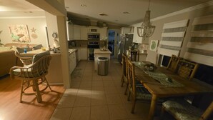 A spacious kitchen with a dining area, wooden furniture, and a chandelier. - Peaceful 3-bedroom house with AC in Flagler Beach (Flagler Beach)