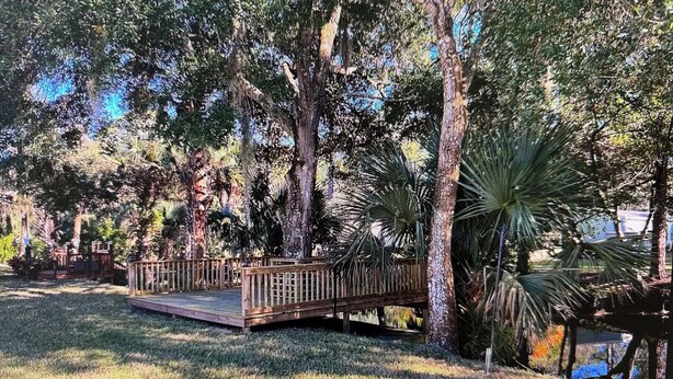 A park with a wooden bridge, trees, and a grassy area. - Peaceful 3-bedroom house with AC in Flagler Beach (Flagler Beach)