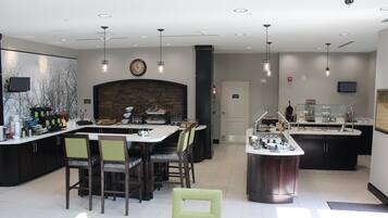 A modern kitchen with a central island, bar area, and seating.