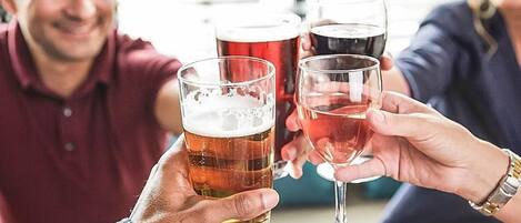 A group of people toasting with glasses of beer and wine.