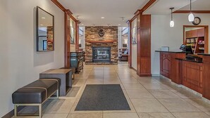 A hotel lobby with a fireplace, seating area, and a reception desk. - Rocklin Suite with Kitchen | Free Daily Breakfast (Rocklin)