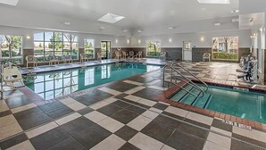 A large indoor swimming pool with checkered flooring, multiple windows, and a sunlit ceiling. - Rocklin Studio w/ Free Breakfast, Hot Tub & Pool (Rocklin)