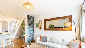 Un soggiorno moderno con un divano, un tavolino da caffè ed scaffali con piante.
