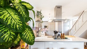 Una cucina moderna con isola centrale, sgabelli da bar, forno a microonde e fornello.