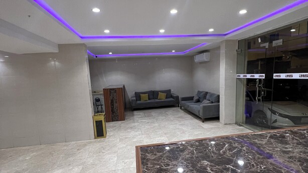 Um quarto espaçoso com piso de mármore, um sofá e um painel de vidro.