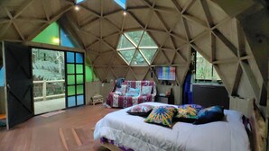A dome-shaped room with a bed, a chair, and a color palette on the wall. - Exclusive Glamping Cabin in Forest, 15 Minutes from José María Córdova Airport (Rionegro)