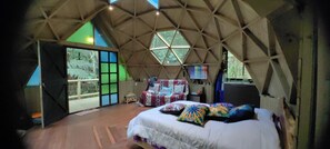 A dome-shaped room with a bed, a chair, and a color palette on the wall. - Glamping Cabin in a Private Forest, 15 Minutes from José María Córdova Airport (Rionegro)