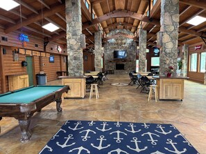 A pool table, bar area, and stone pillars in a lodge's interior. - Cozy 1 bedroom 1 bath with loft  tiny home 2 pools & hot tub Lake Travis (Austin)