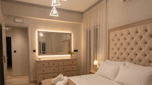 Un dormitori d'hotel amb un llit gran, una petita taula de nit, un mirall i una làmpada al sostre.