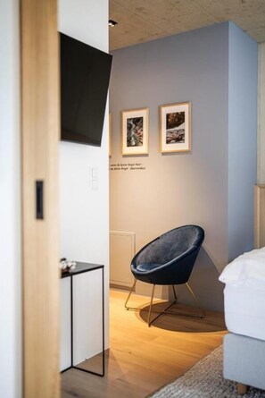A modern room with a bed, a chair, and two framed pictures on the wall. - Lebe' Oetz im Ötztal  (Oetz)