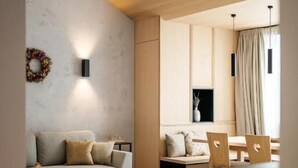Una sala de estar moderna con un sofá, una silla y un comedor con mesa y sillas.