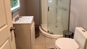 Ein Badezimmer mit Duschkabine, Waschbecken und Toilette.
