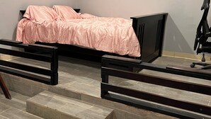 Ein Schlafzimmer mit einem Bett, einem Sessel und einem Schreibtisch.
