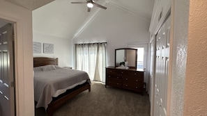 A bedroom with a bed, dresser, ceiling fan, and a window with curtains. - Quiet Country Retreat East of Nappanee — Relax, Recharge, and Unwind (Nappanee)