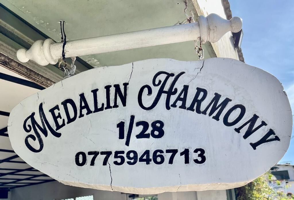A white sign with 'Medalinn Harmony' and a phone number.