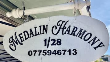 A white sign with 'Medalinn Harmony' and a phone number.