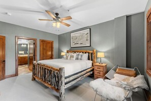 A bedroom with a wooden bed, a ceiling fan, a nightstand, a lamp, a fur throw, and a framed picture on the wall. - Ski In/Out Beaver Creek I Slopeside Retreat W/Pool (Avon)