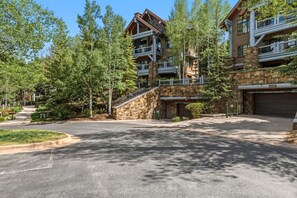 Eine Lodge mit einer Stein-Fassade, mehreren Balkonen und einem Parkplatz.