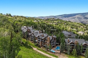 Eine Lodge mit mehreren Gebäuden, einem Pool und einer Bergkulisse.