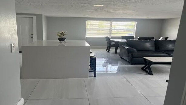 Un salon moderne comprenant un canapé, une table basse et un coin repas avec une table et des chaises.