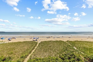 Ein Strand mit Menschen, Zelten und blauem Himmel.