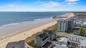A coastal town with a beach, residential buildings, and a pier extending into the sea. - 1 Bedroom Beachfront Condo! (Old Orchard Beach)