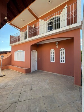 A two-story building with a balcony, a door, and two windows. - Cozy house/São Lourenço Pet friendly (São Lourenço)