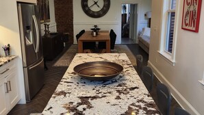 Una cucina con isola centrale, elettrodomestici in acciaio inossidabile, una sveglia e illuminazione a sospensione.
