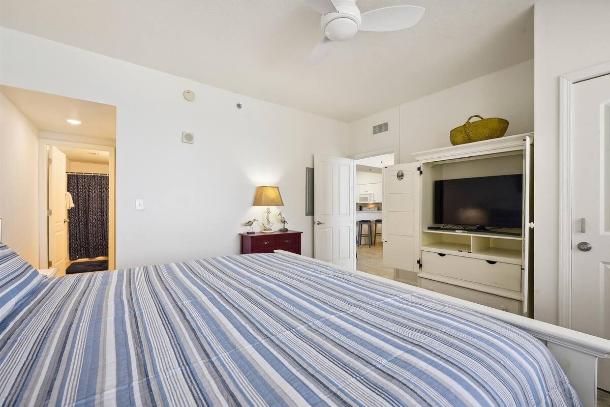 Ein Hotelzimmer mit Bett, Schreibtisch, Fernseher und Kleiderschrank.