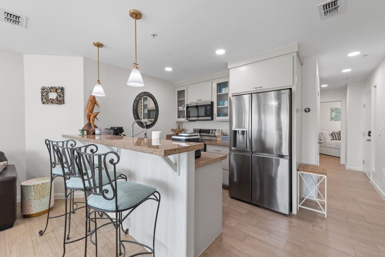 A modern kitchen with a central island, stainless steel appliances, and pendant lighting.
