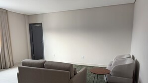 Un salon moderne avec un canapé, un fauteuil et une petite table ronde.