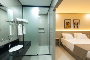 Un baño moderno con cabina de ducha de vidrio, un lavamanos con grifo cromado y un perchero para toallas.
