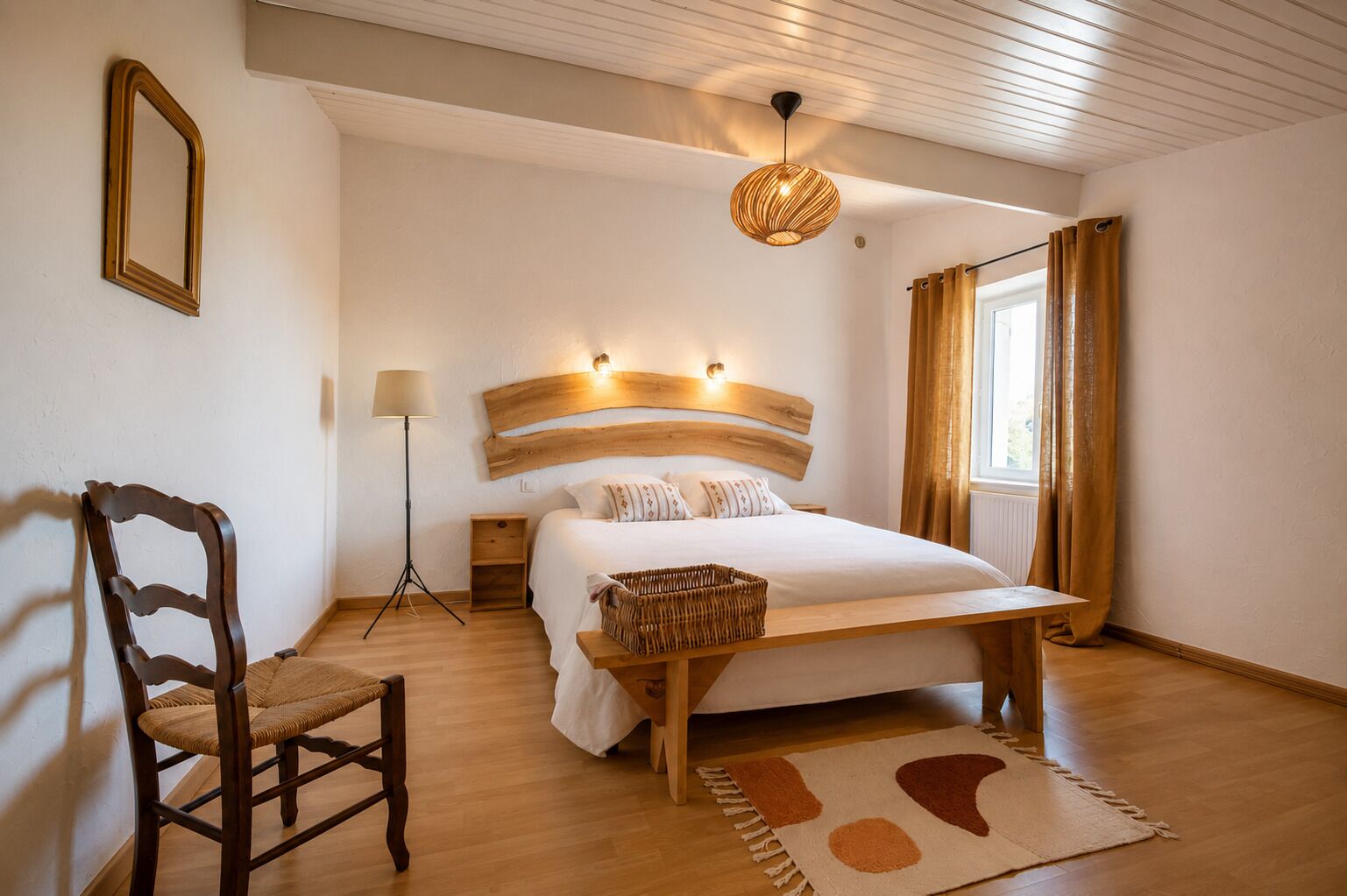 A bedroom with a wooden bed, a bedside table, a chair, a floor lamp, and a window with curtains.