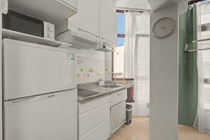 Eine kleine Küche mit Backofen, Mikrowelle und Spüle.