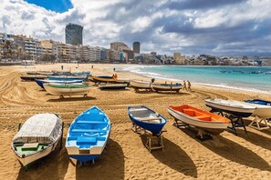 A beach with several boats lined up on the sand, a clear sky, and buildings in the background. - Vacation Studio 'Morada Mágica' with Sea View, Wi-Fi and Air Conditioning (Las Palmas de Gran Canaria)