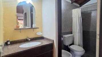 Un baño con lavamanos, espejo y dos inodoros.