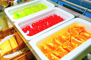 A buffet with various food items including orange slices and a dish with red spherical items. - Homeinn neo Xiamen Lianban Metro Station (Xiamen)