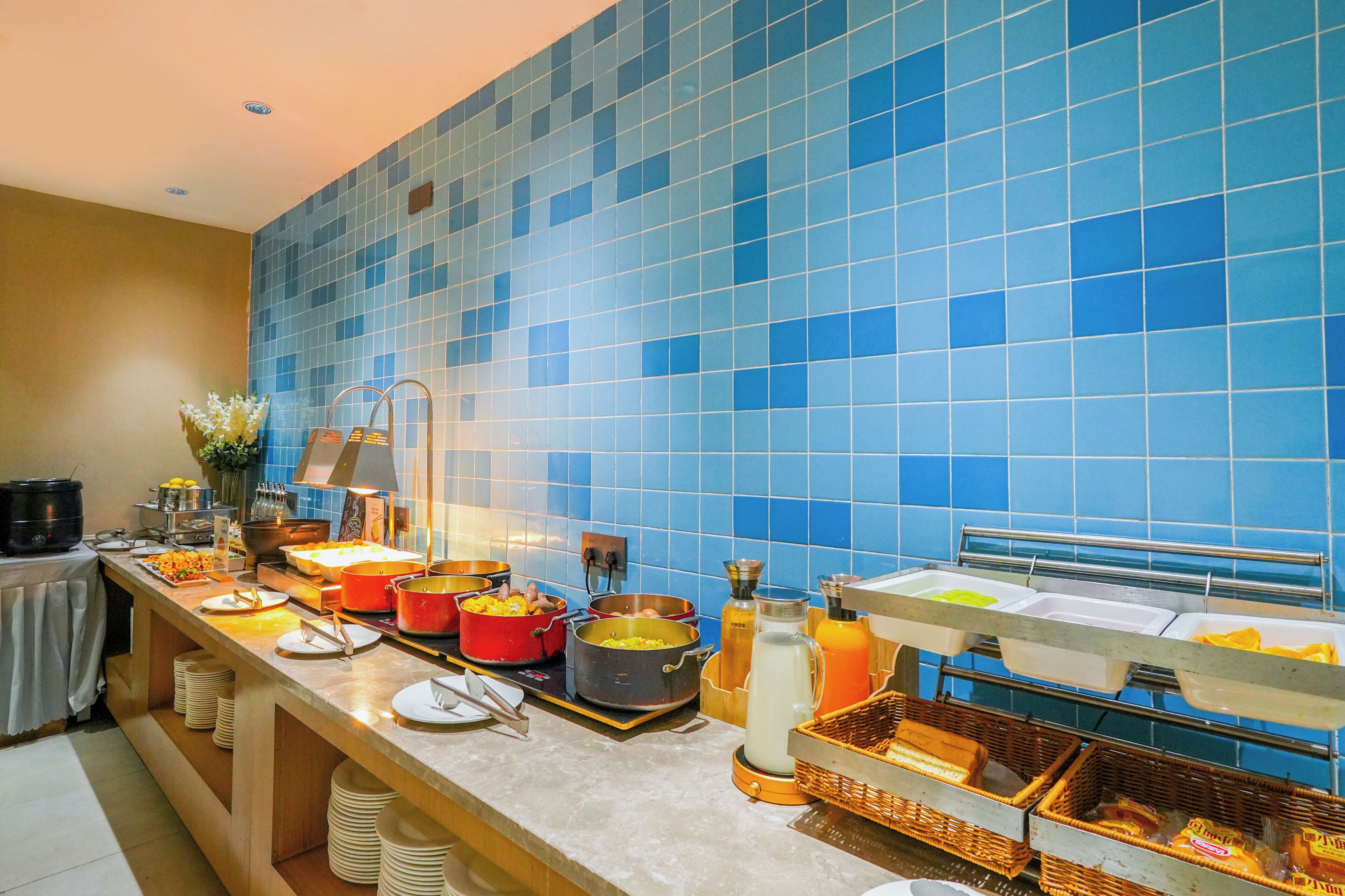 A buffet setup with various food items and serving utensils.