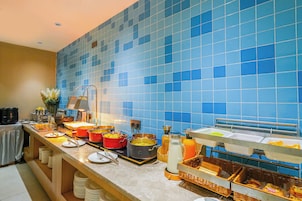 Una barra de buffet con diversos alimentos y utensilios para servir.