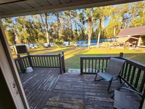 A wooden deck with a bench and a TV. - Cozy home away from home. (Lake City)