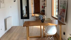 Ein modernes Wohnzimmer mit einem Holzespeisetisch, einem braunen Ledersofa und einem Glastisch.