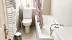 Kylpyhuone, jossa on wc, kylpyamme, suihku ja patteri.