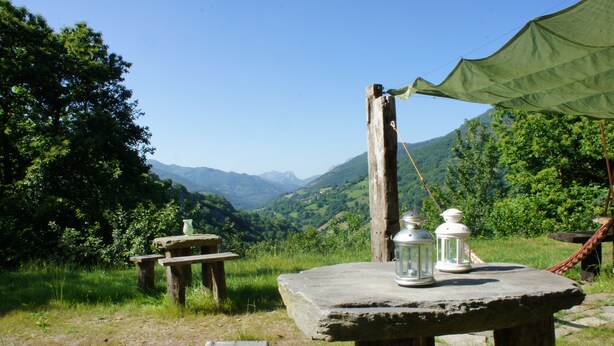 A rustic outdoor setting with a stone table, two lanterns, and a green canopy. - The LLananzanes Lookout—Asturias Rural—CASA II (Conforcos (Aller))