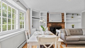 Un comedor con una mesa preparada para dos personas, un sofá y una chimenea.