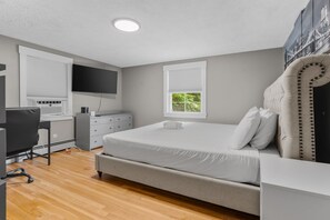A bedroom with a bed, a desk, a chair, a wardrobe, and a window with blinds. - Cozy 2BR Family Home with Fire Pit and Backyard (Barnstable)
