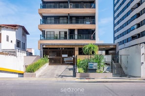 A multi-story building with a modern design, featuring a gated entrance, a staircase, and a sign indicating the building number 402. - Comfort in Condo w/ Pool in Pituba Hpa0202 (Salvador)