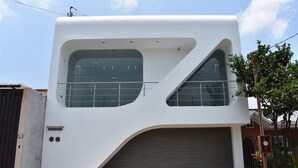 Ein modernes Gebäude mit großen Fenstern und einer Garagentür.
