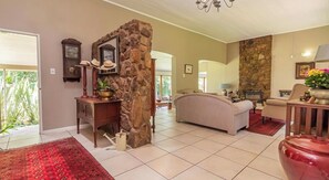 Un salón espacioso con un pilar de piedra, una chimenea y un ventanal grande.