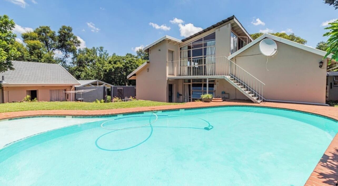 A modern two-story house with a swimming pool, a covered patio, and a staircase leading to the upper floor.