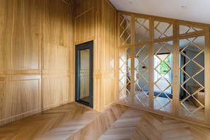 A room with wooden paneling, a herringbone floor pattern, and a sliding door with a geometric design. - Villa Émeraude: A stunning villa located 150 meters from the beach. (Arcachon)